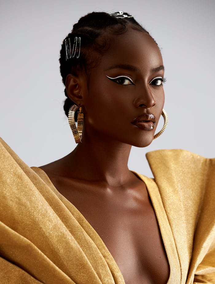 Stunning portrait of a woman in a glamorous gold dress, showcasing elegance and style.